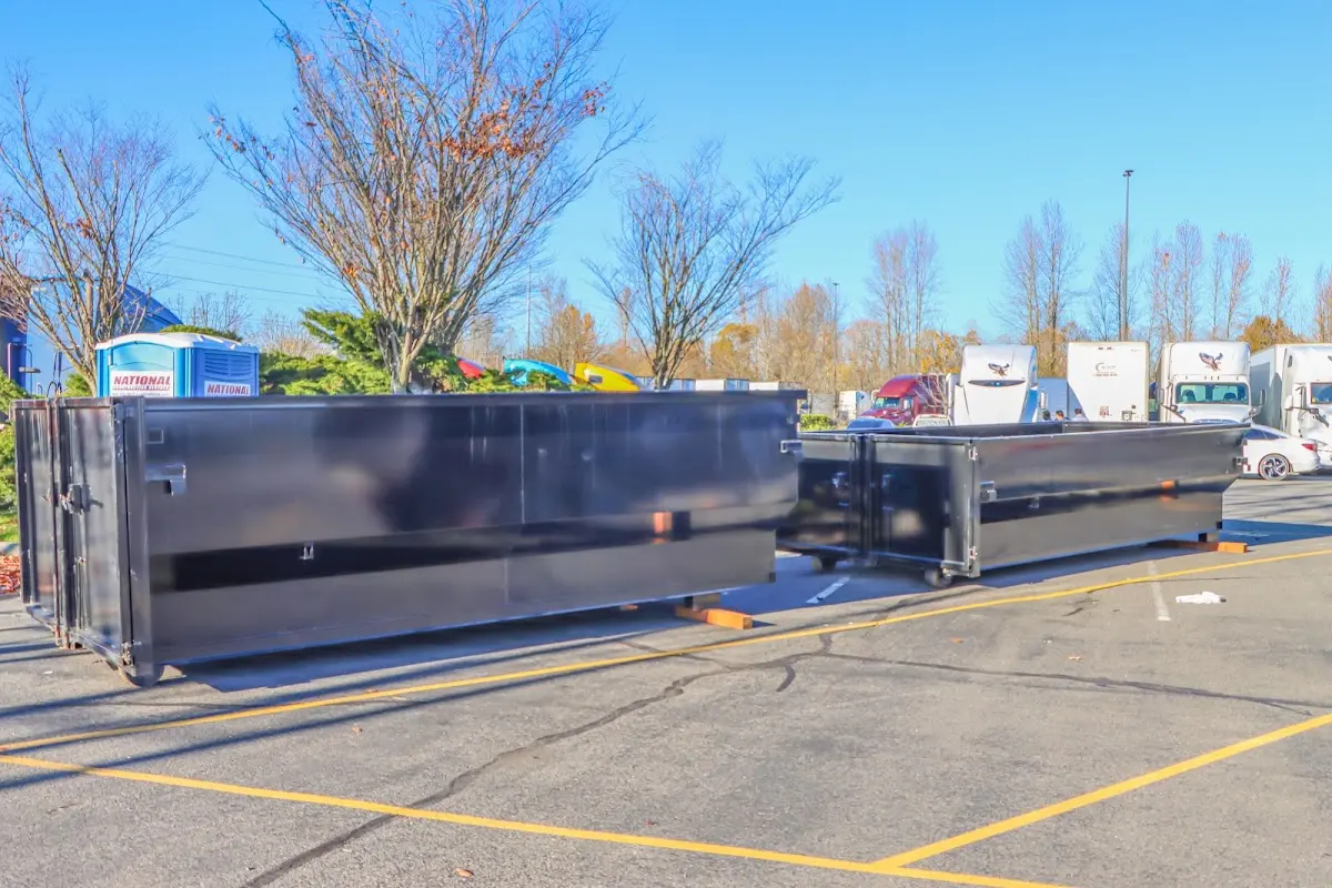 Professional dumpster rental service with roll-off container on residential driveway in Laurel